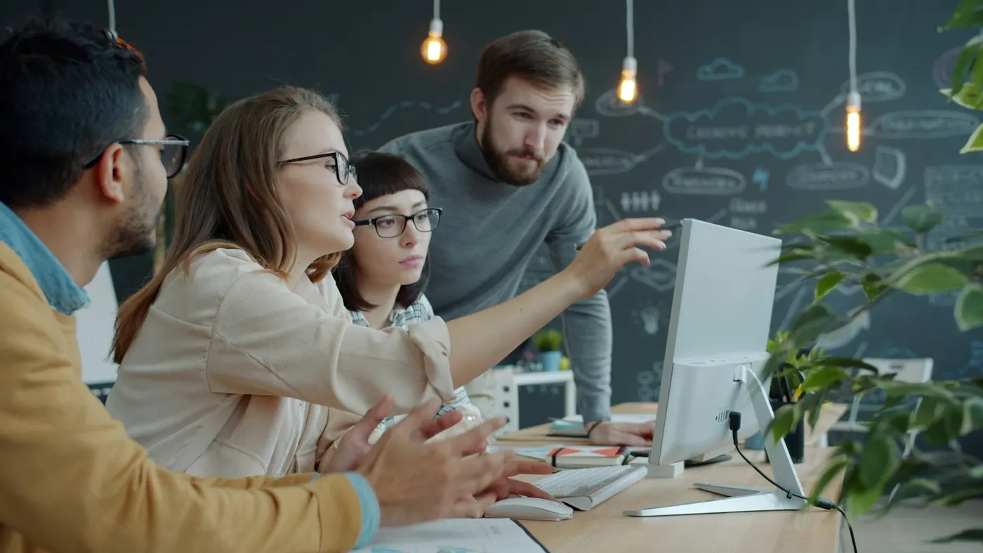A team gathered around a computer in an office